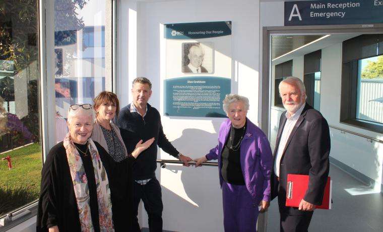 Bass Coast Health CEO Jan Child, left, and former Board Chair Don Paproth, right, with the honour board for Stan Grabham and his family, Angie Almond, Arthur Grabham and Shirley Grabham at the unveiling.