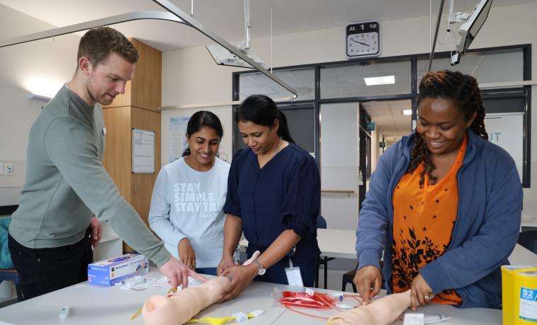 Bass Coast Health Clinical Nurse Educator Liam Kennedy runs through a training session with international Nursing recruits, from left, Registered Nurses Rosina Joseph, Nisha Muttilayil Kesavan and Chioma Nwokoye.