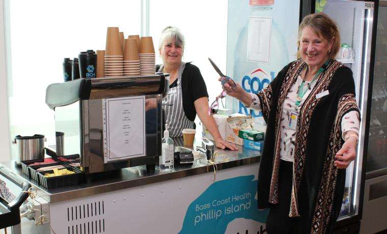 Phillip Island Health Hub Auxiliary Outgoing President Lyn Wadeson cuts the ribbon to open the coffee cart at the Phillip Island Health Hub at Cowes, with barista Sue Gale.