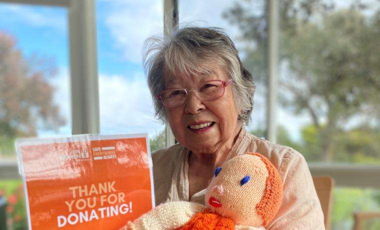 Griffiths Point Lodge resident Betty Pescud with ‘Jordan’, the mascot she knitted for The Vintage Crusaders to take part in the United Nations’ ‘Safe. Everywhere. Always.‘ Walk on Monday 25 November.